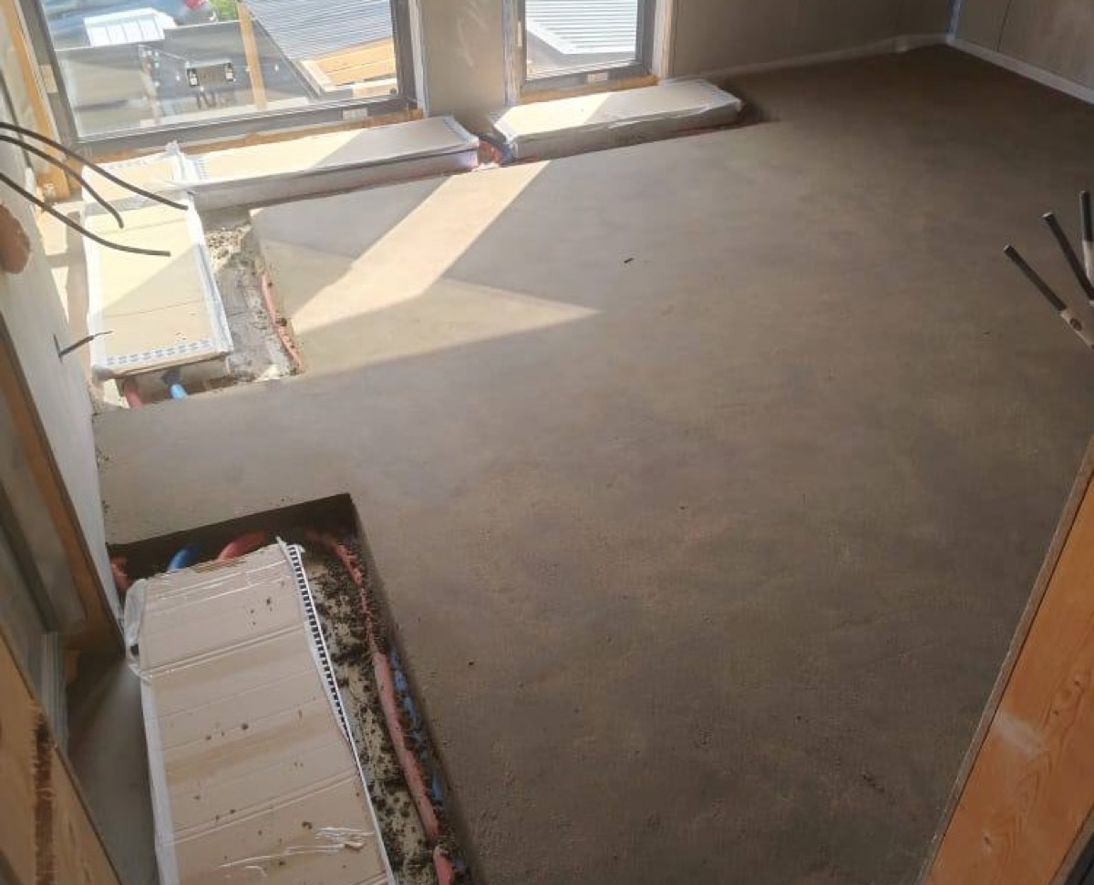 Полусухая стяжка в частном доме 120 м² в КП Карамель — комната с панорамными окнами и выводами коммуникаций в полу