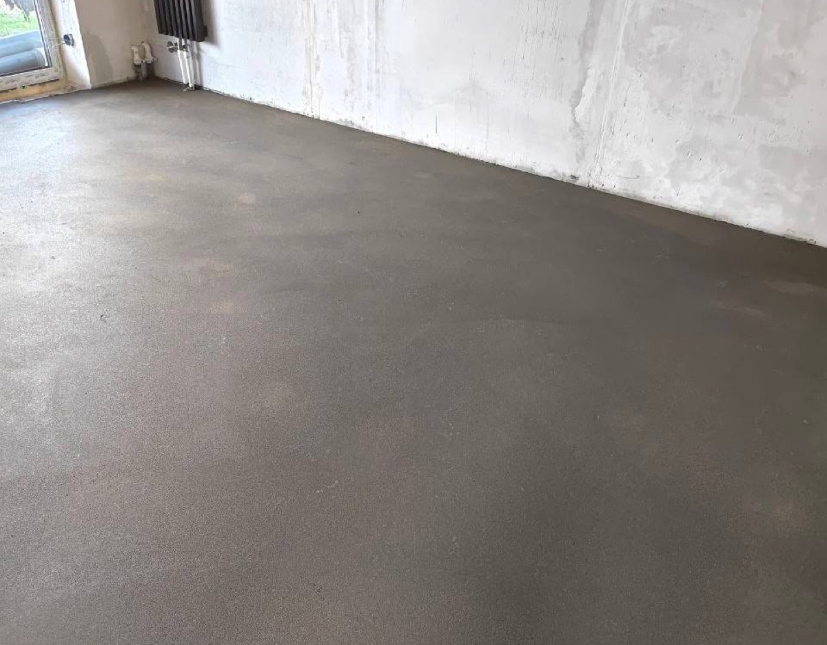 Полусухая стяжка в комнате дома 120 м² в Раменском округе — ровный слой у радиатора под окном