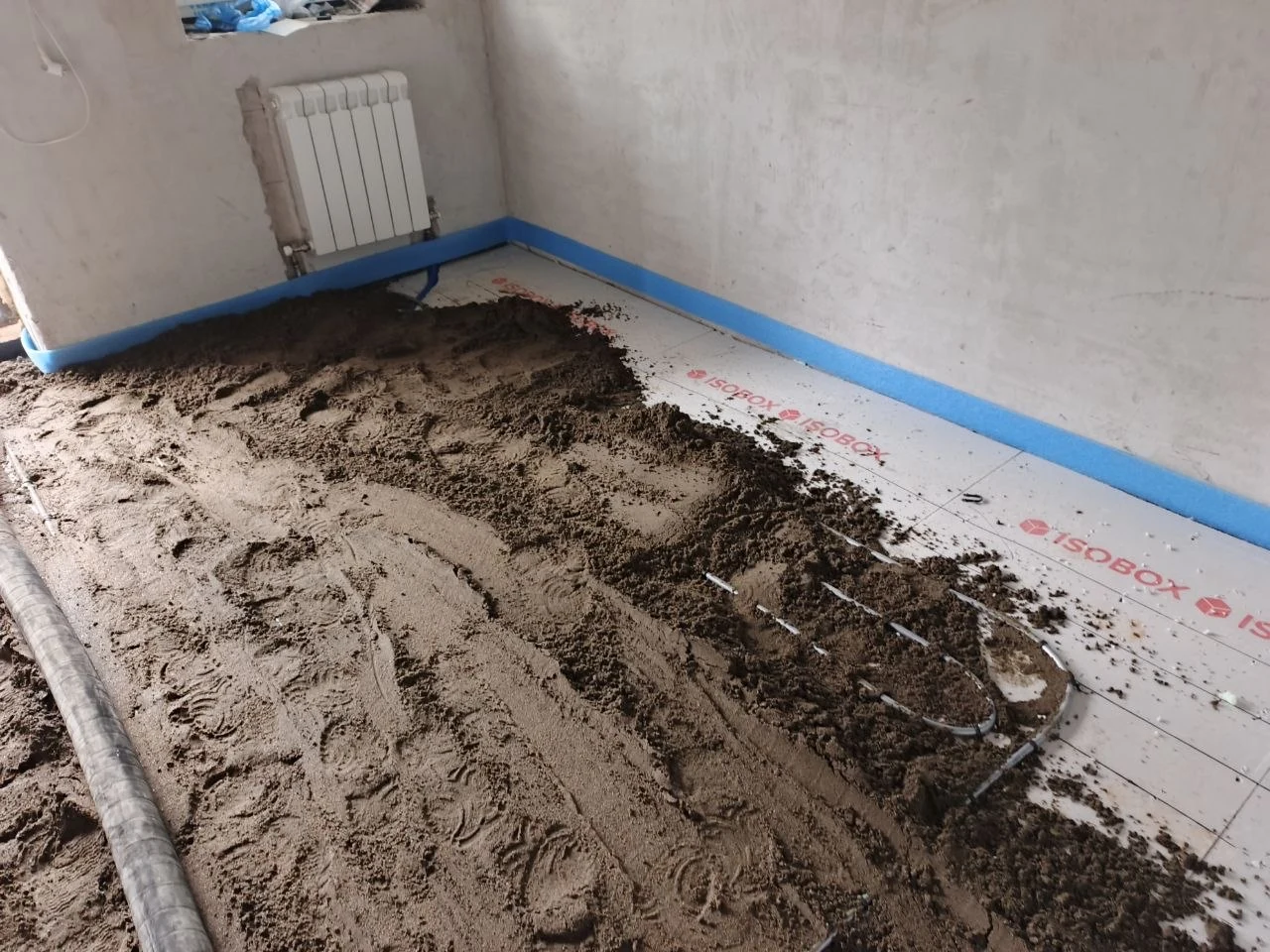 Укладка полусухой стяжки по водяному теплому полу в доме 130 м² в Старотеряево - трубы контуров на плитах утеплителя, синяя демпферная лента по периметру