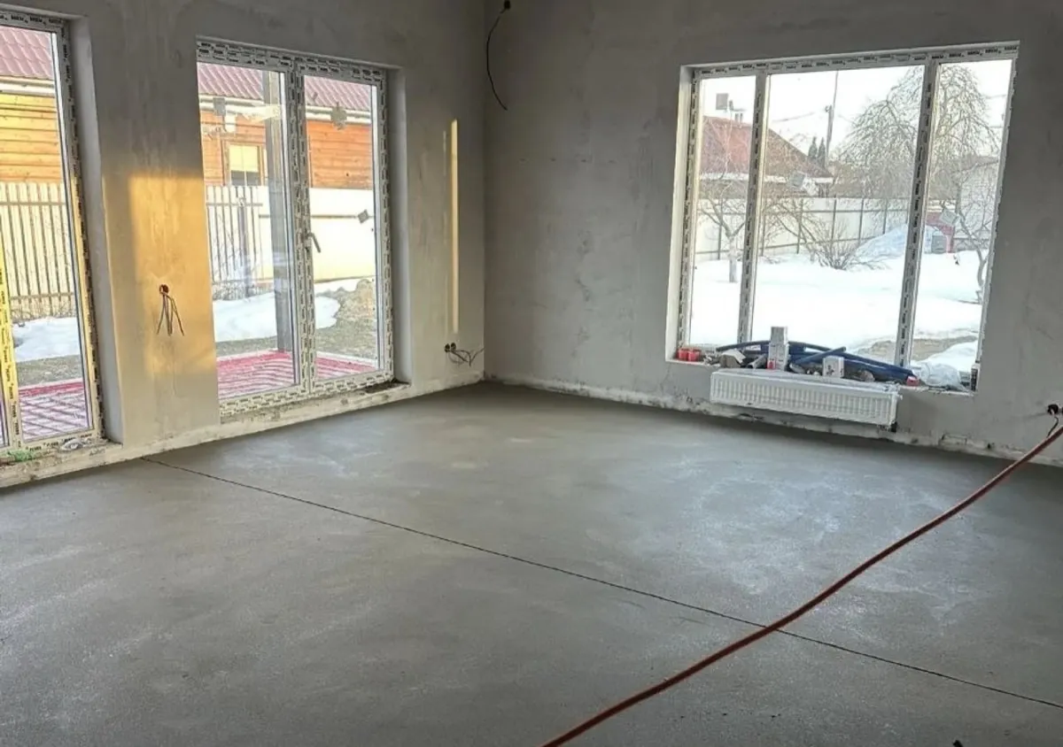 Полусухая стяжка 150 м² в частном доме в деревне Стулово - гостиная с панорамными окнами и узкими радиаторами под окнами