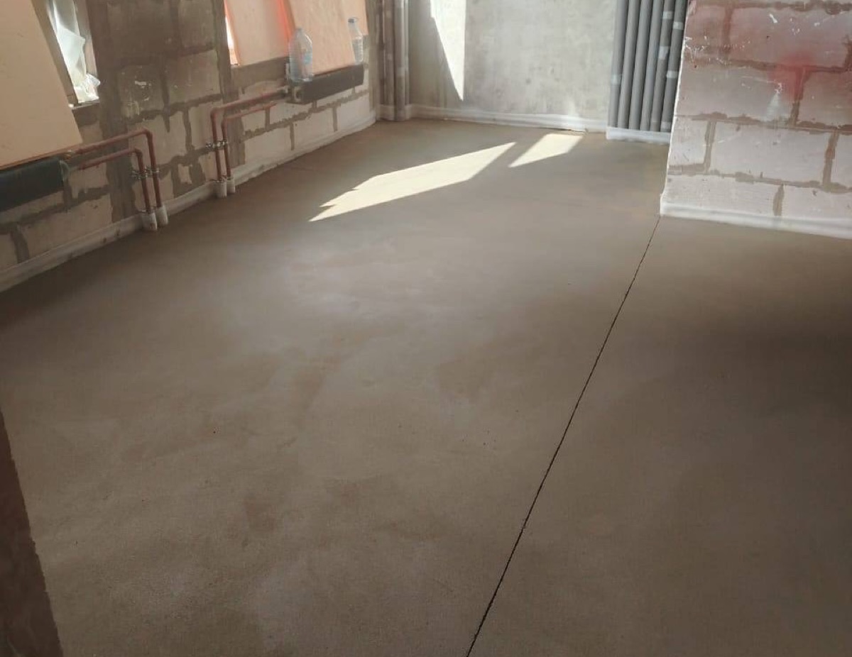 Полусухая стяжка в магазине 150 м² в ЖК Сигнальный — помещение с окнами и радиатором отопления