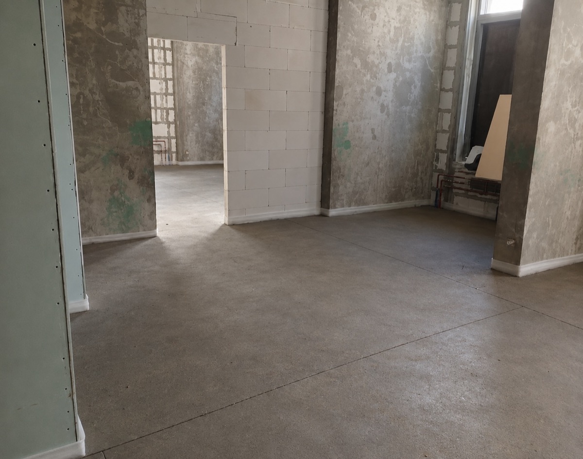 Полусухая стяжка пола 150 м² в магазине в ЖК Сигнальный в Москве — ровная поверхность в большом помещении с проемами
