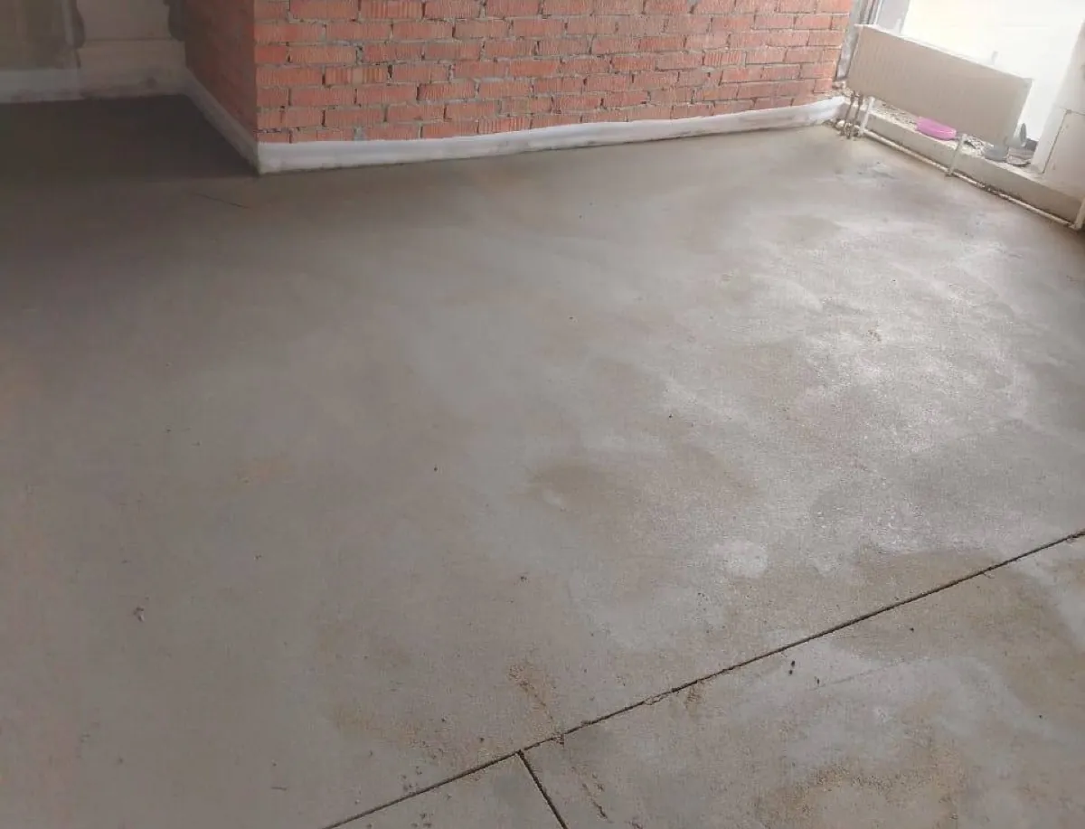 Полусухая стяжка в магазине 110 м² в Троицке - угол с кирпичной стеной и радиатором