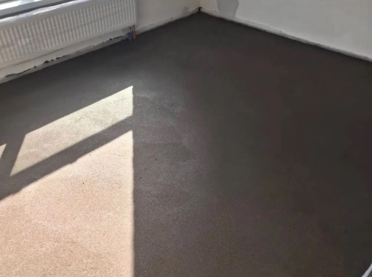 Полусухая стяжка пола 84 м² в квартире на улице Барклая в Москве — ровная поверхность в комнате у радиатора под окном