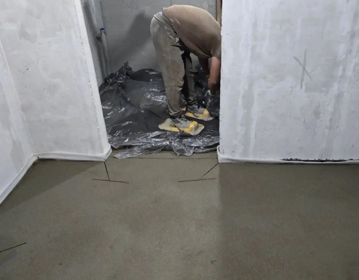 Полуручной монтаж полусухой стяжки в квартире 84 м² на улице Барклая в Москве — мастер затирает поверхность, демпферная лента по периметру