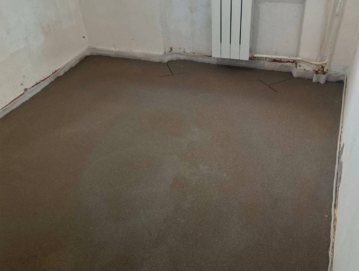 Свежая полусухая стяжка в комнате квартиры 45 м² на Байкальской улице в Москве — ровная поверхность и компенсационный шов