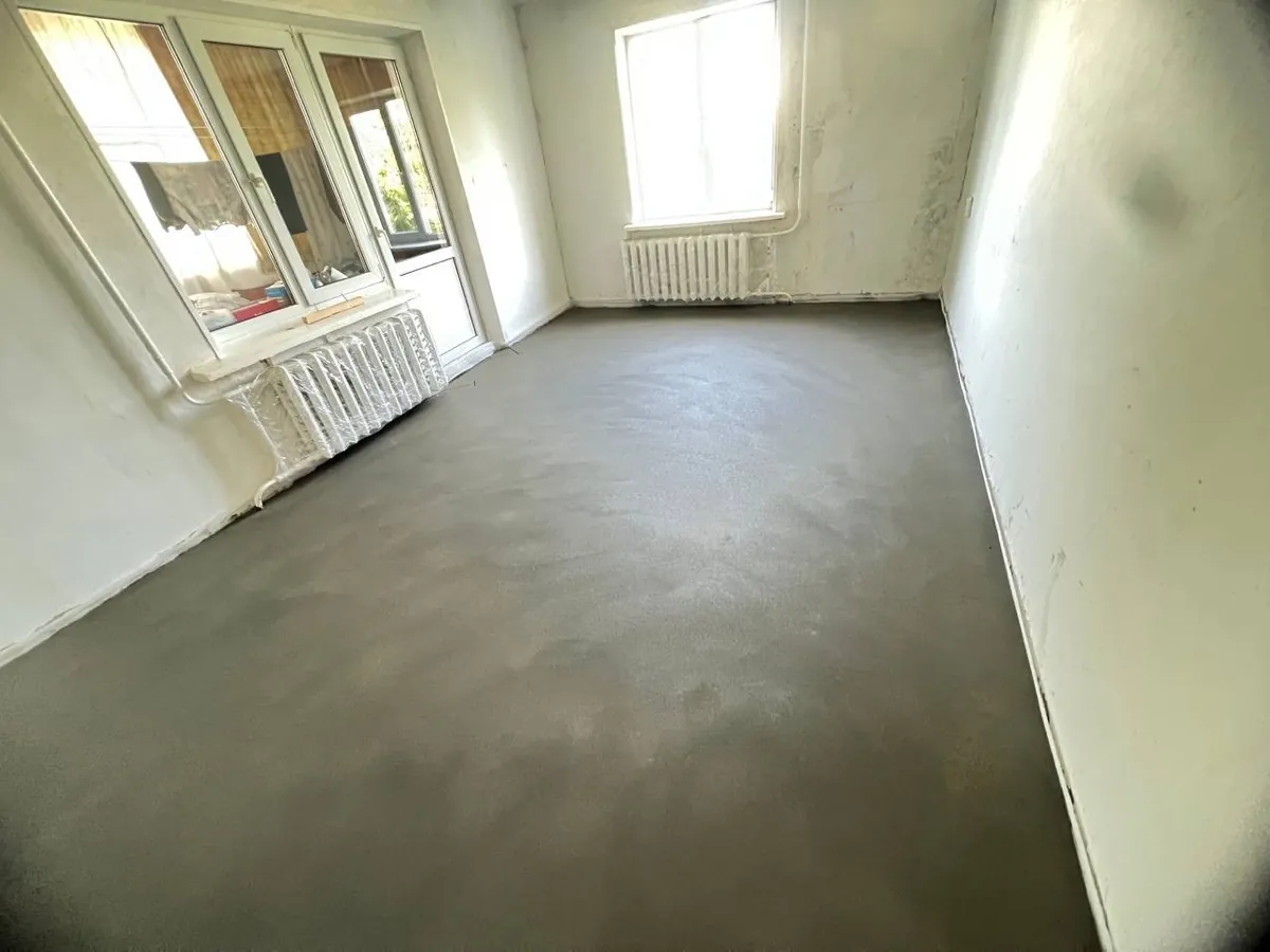 Полусухая стяжка в комнате квартиры 37,8 м² в Ельдигино - ровная поверхность у окон, радиаторы защищены пленкой