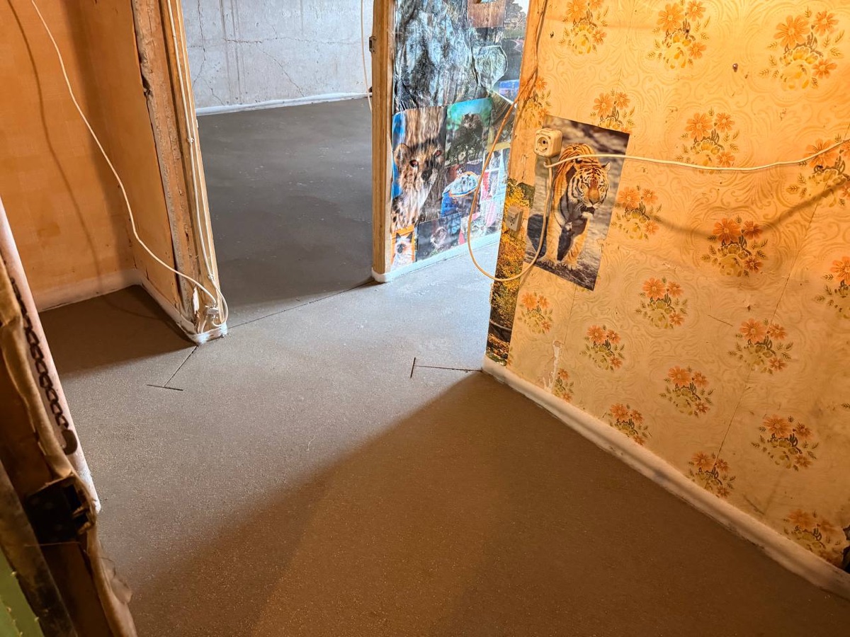 Свежая полусухая стяжка в комнате квартиры 28 м² на улице Николая Химушина в Москве - ровный слой с компенсационным швом