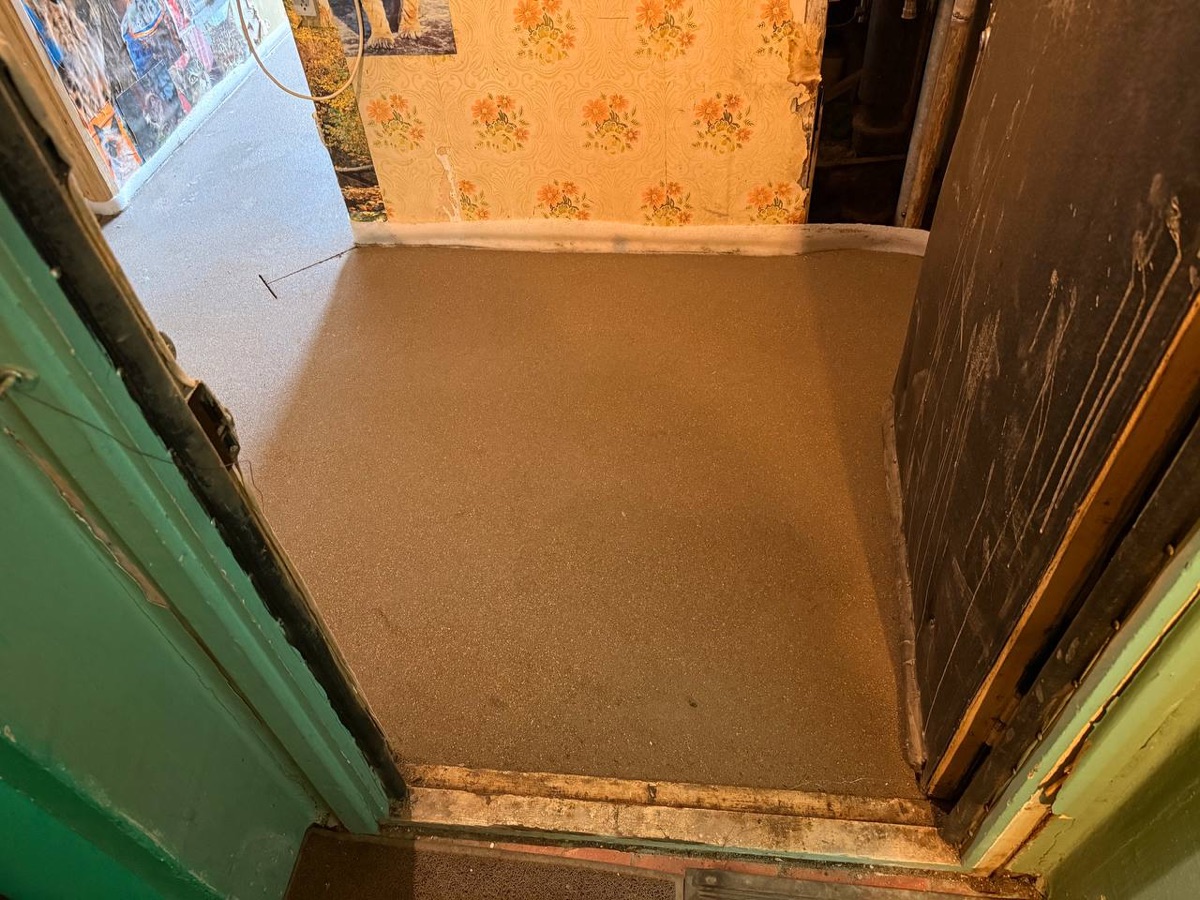 Полусухая стяжка в прихожей квартиры 28 м² на улице Николая Химушина в Москве - ровная поверхность у входа, демпферная лента по периметру