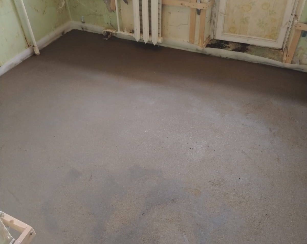 Полусухая стяжка в комнате квартиры 42 м² в Ильинское-Усово — чугунный радиатор отопления и ровный пол