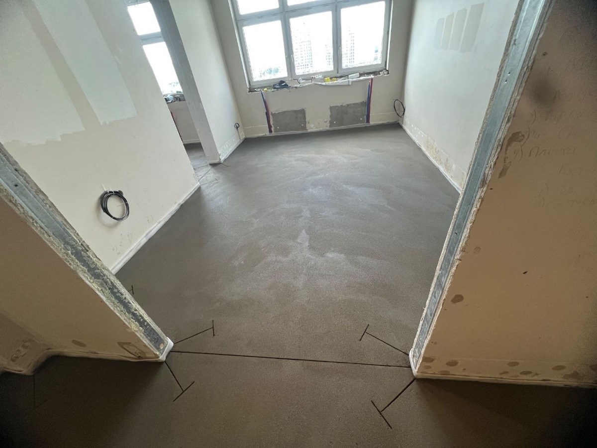 Полусухая стяжка в комнате квартиры 78,3 м² на Нагатинской набережной — панорамные окна и ровный слой под чистовое покрытие