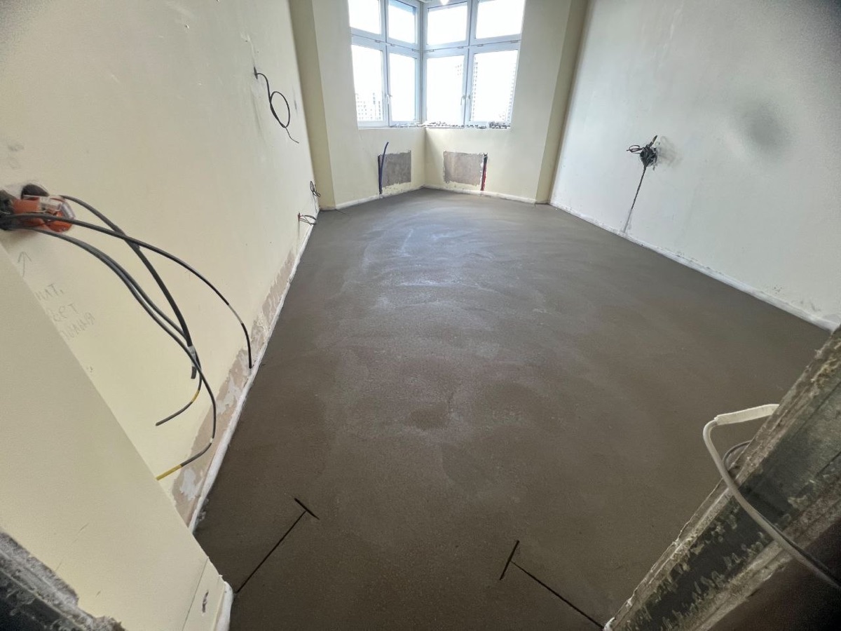 Полусухая стяжка в квартире 78,3 м² на Нагатинской набережной в Москве — ровная поверхность у окна на высоком этаже