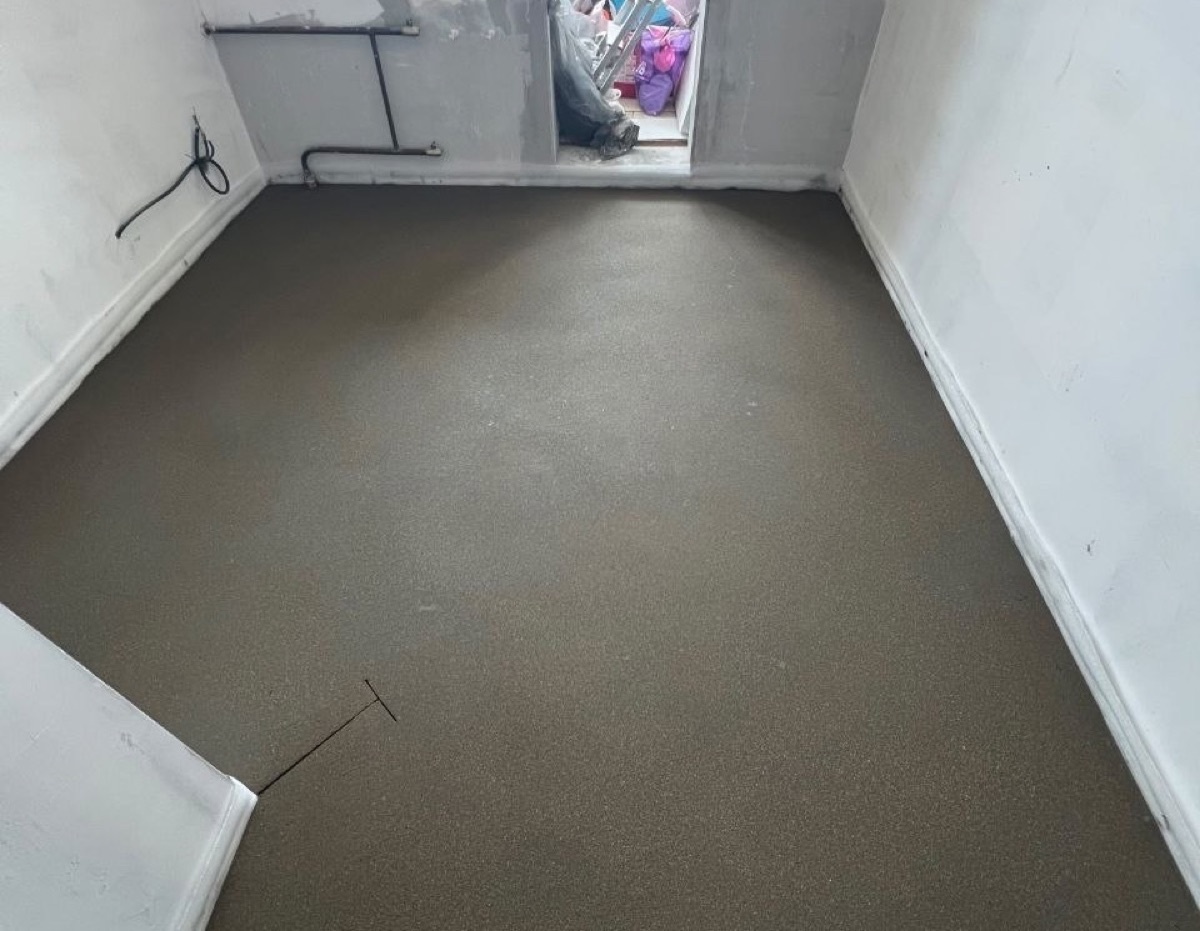 Полусухая стяжка в комнате квартиры 54 м² в Видном — ровная поверхность и компенсационный шов у дверного проема