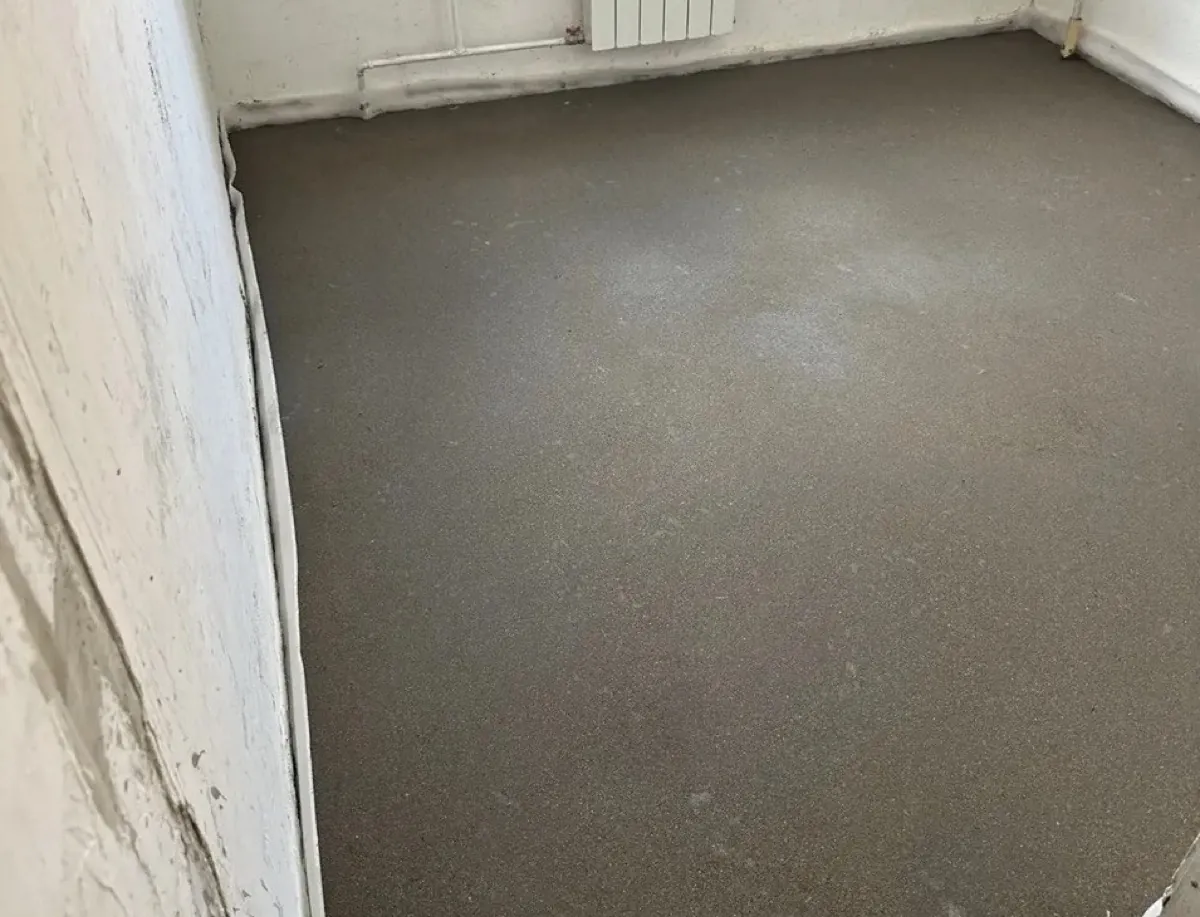 Полусухая стяжка пола 60,7 м² в квартире в поселке Власиха - ровная поверхность в комнате у радиатора