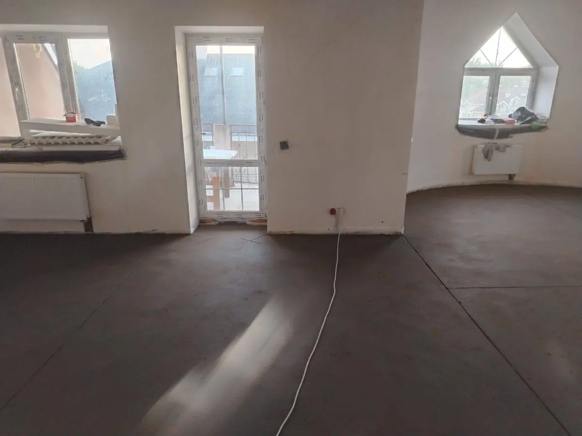 Полусухая стяжка в квартире 121,6 м² в КП Заповедное Озеро - комната с выходом на балкон и эркерным окном