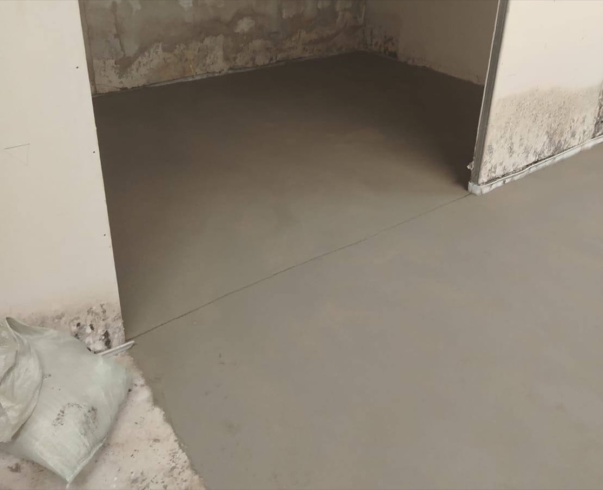 Готовый пол после полусухой стяжки в торговом центре 253 м² на Дубнинской улице — ровная поверхность в проеме